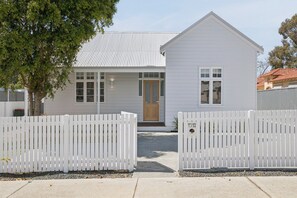A white single-story house with a front door, windows, and a picket fence. - Three-Bed Vic Park Haven (Victoria Park)