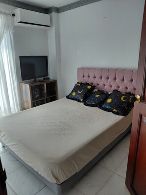 Ein Schlafzimmer mit einem Bett, einem Fernseher und einer Stereoanlage.