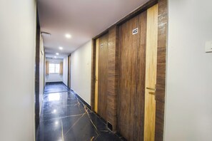 A corridor with wooden doors numbered 402 and 403, leading to rooms.
