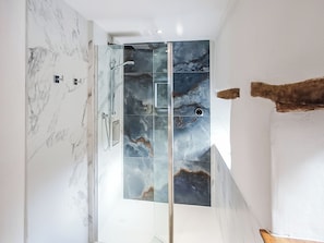 A modern bathroom with a glass shower enclosure, marble walls, and a wooden accent. - South Nethercott Farm Annexe (Okehampton - Whiddon Down)