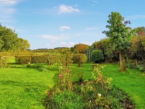 Un jardí ben cuidat amb diferents plantes i una construcció petita.