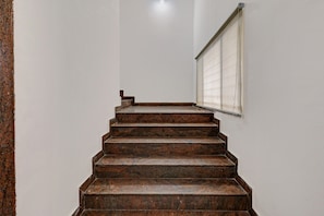 A staircase with a handrail and a window with blinds. - Hotel O Pride Inn (Bangalore)
