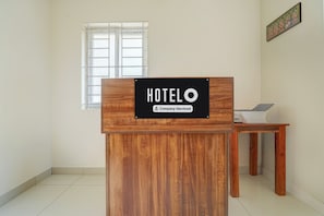 A wooden reception desk with a sign indicating it's a company-serviced hotel.