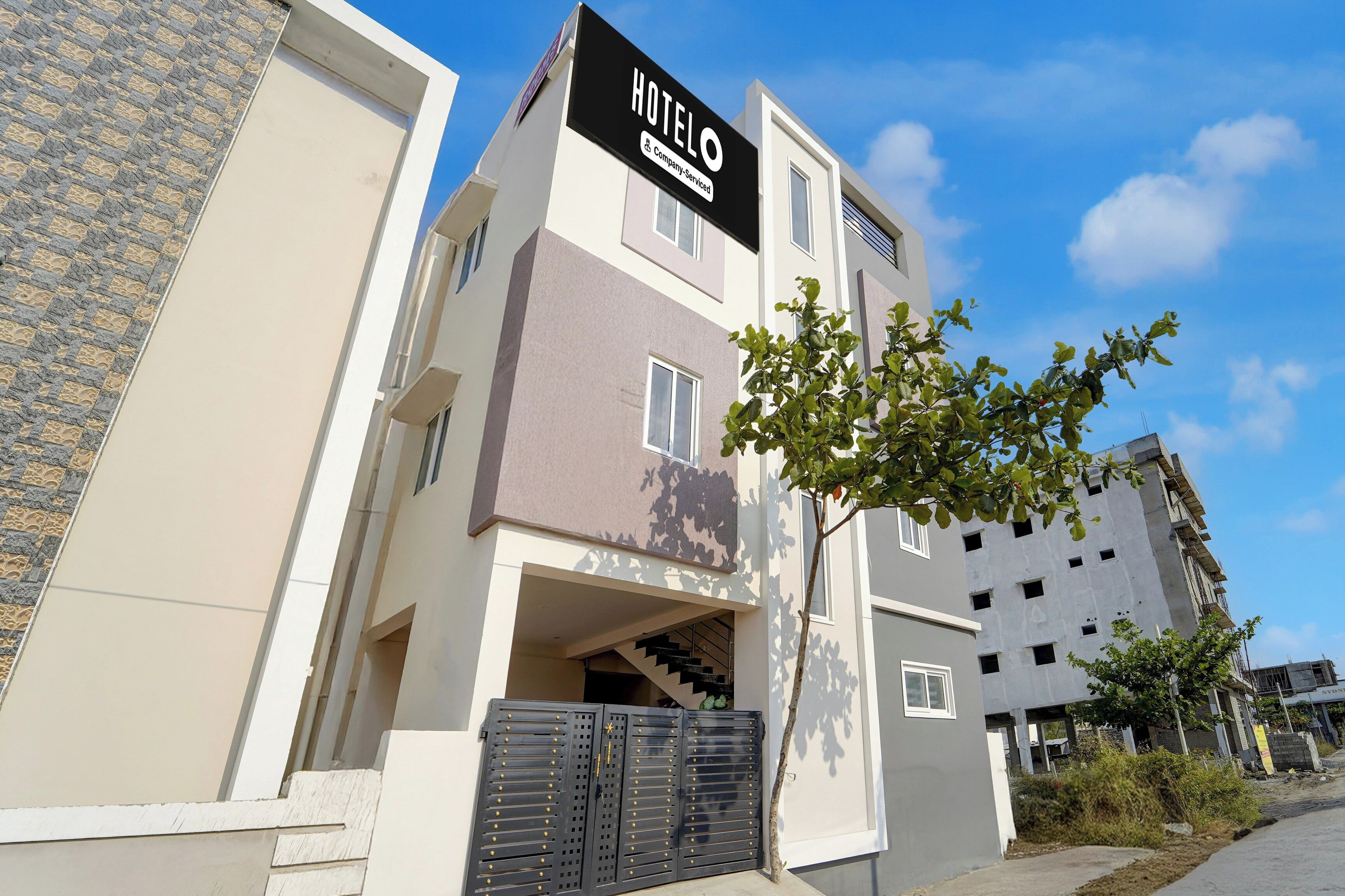 A modern hotel building with a sign reading 'HOTEL & Company Service'.