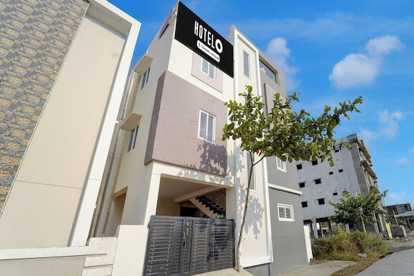 A modern hotel building with a sign reading 'HOTEL & Company Service'.