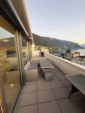 A balcony with a view of a lake and mountains, furnished with a table and benches. - A View to Remember VD (Montreux)