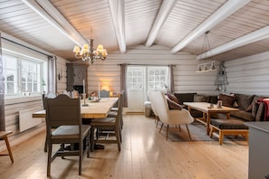 A cozy interior with a wooden dining table, chairs, a sofa, and a chandelier. - FA674- 5 Bedrooms, Private Sauna and Ski Access (Trysil)