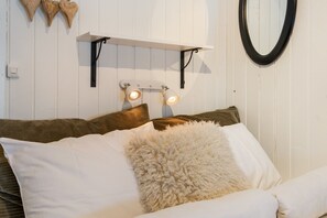 A bed with white and brown bedding, a fluffy white pillow, and a wall-mounted shelf with two wall sconces. - FA674- 5 Bedrooms, Private Sauna and Ski Access (Trysil)