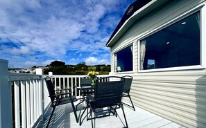 Varanda com mesa e cadeiras, com vista para uma paisagem deslumbrante.
