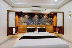 Une chambre moderne avec un grand lit, un mur décoratif et un éclairage intégré.