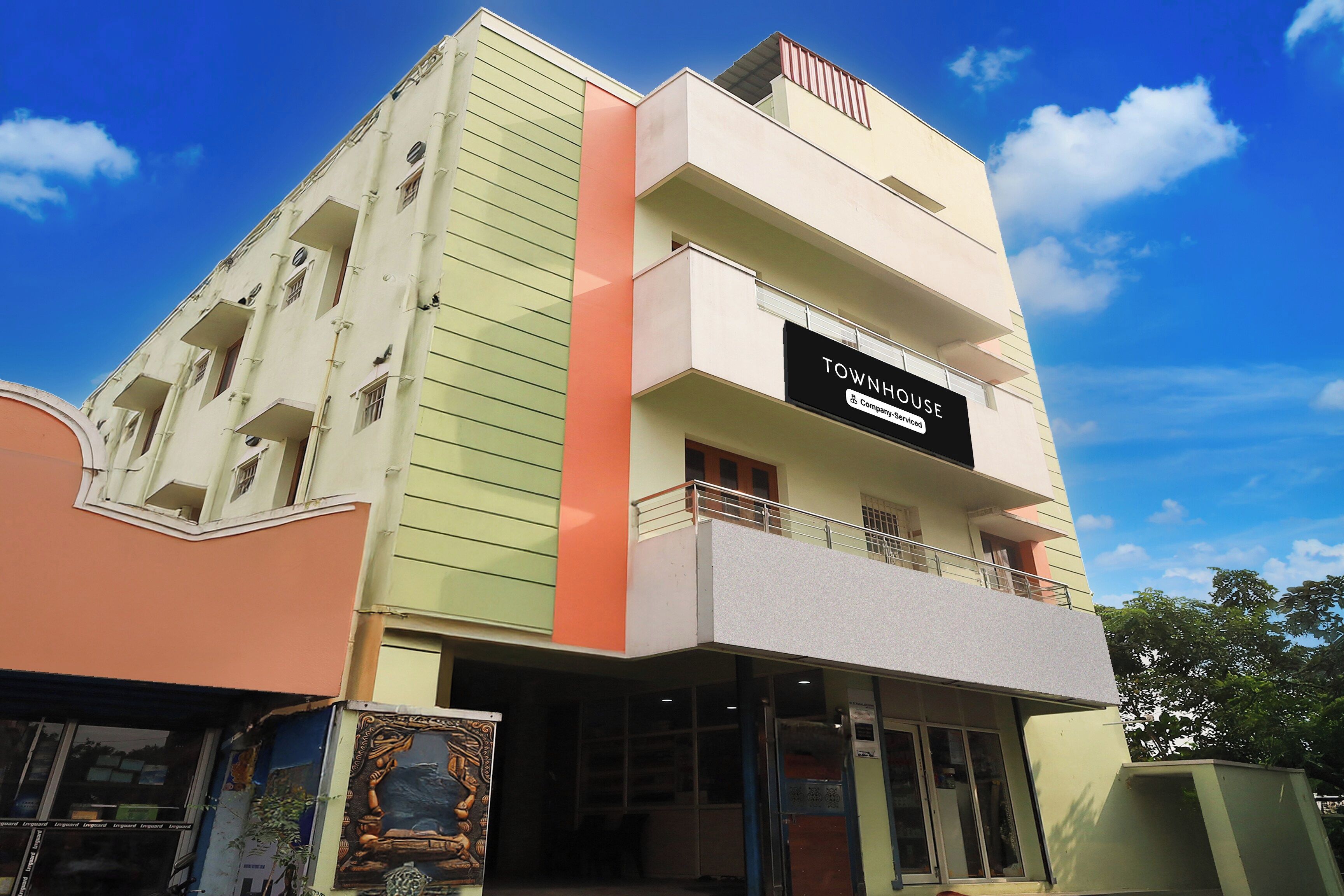 Un edificio de varios pisos con un cartel que indica que es una casa adosada con servicios de empresa.