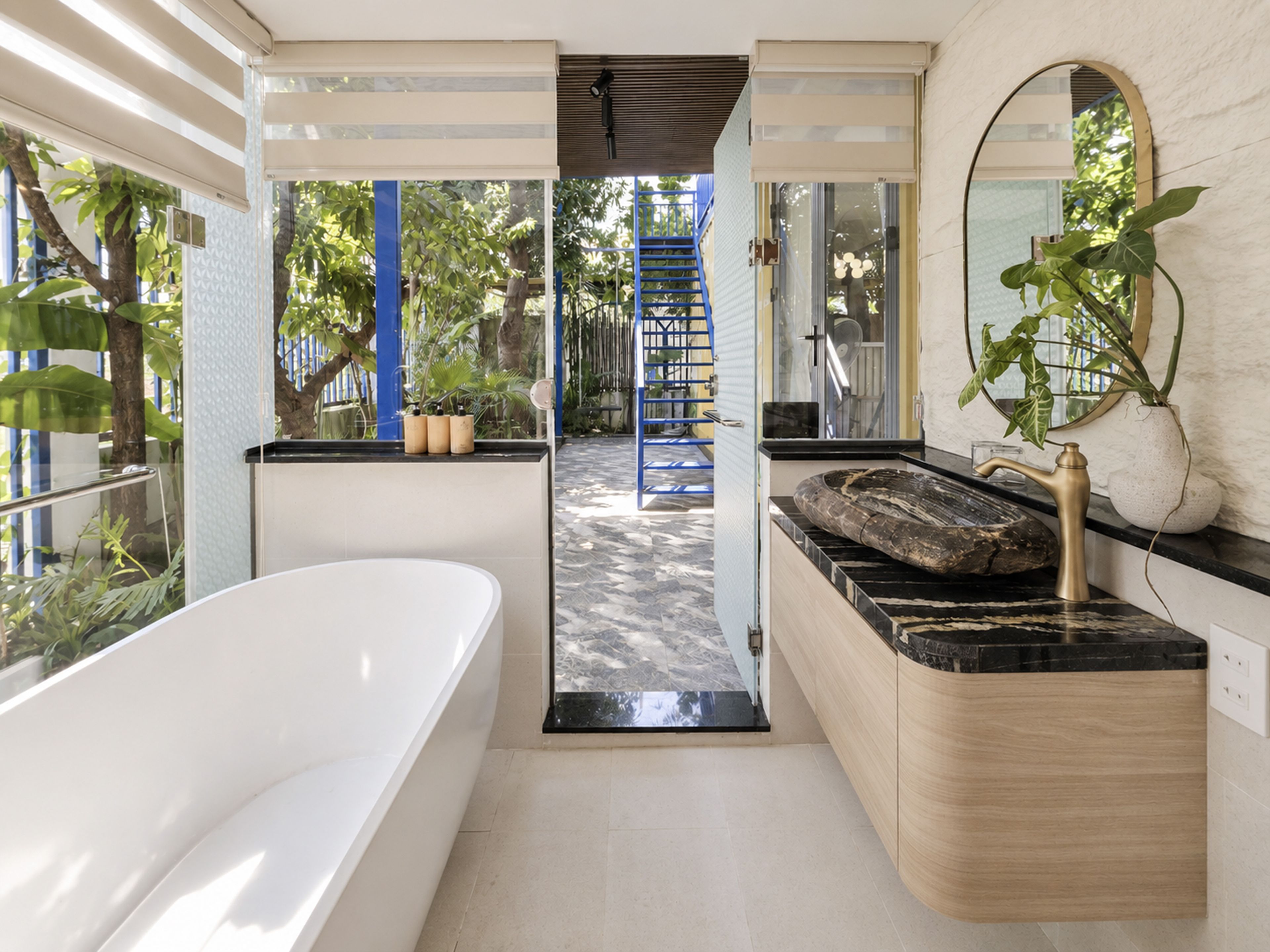 Un baño moderno con una bañera, un lavabo con encimera de mármol y un espejo grande.
