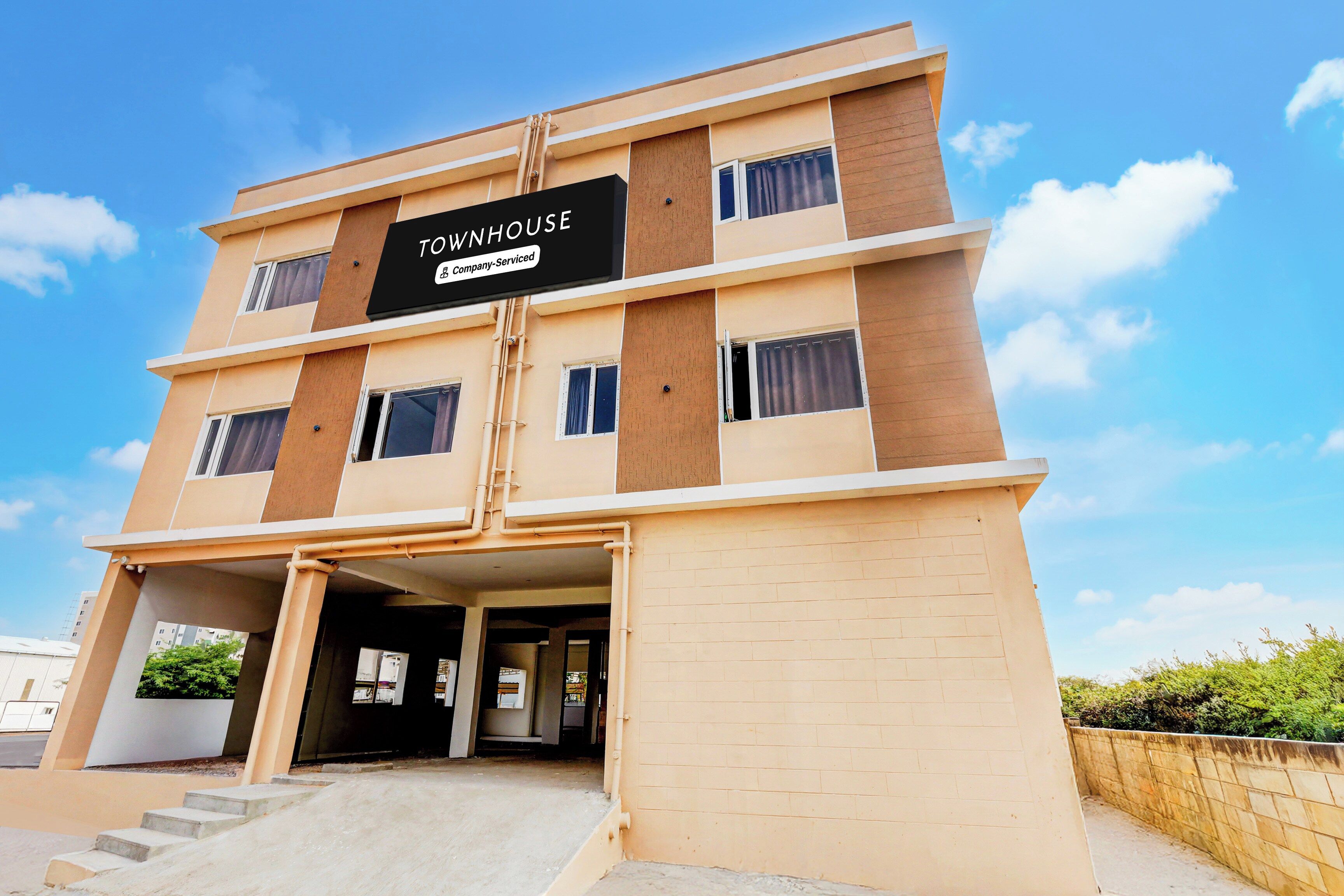 A multi-story building with a sign that reads 'TOWNHOUSE Company Serviced'.