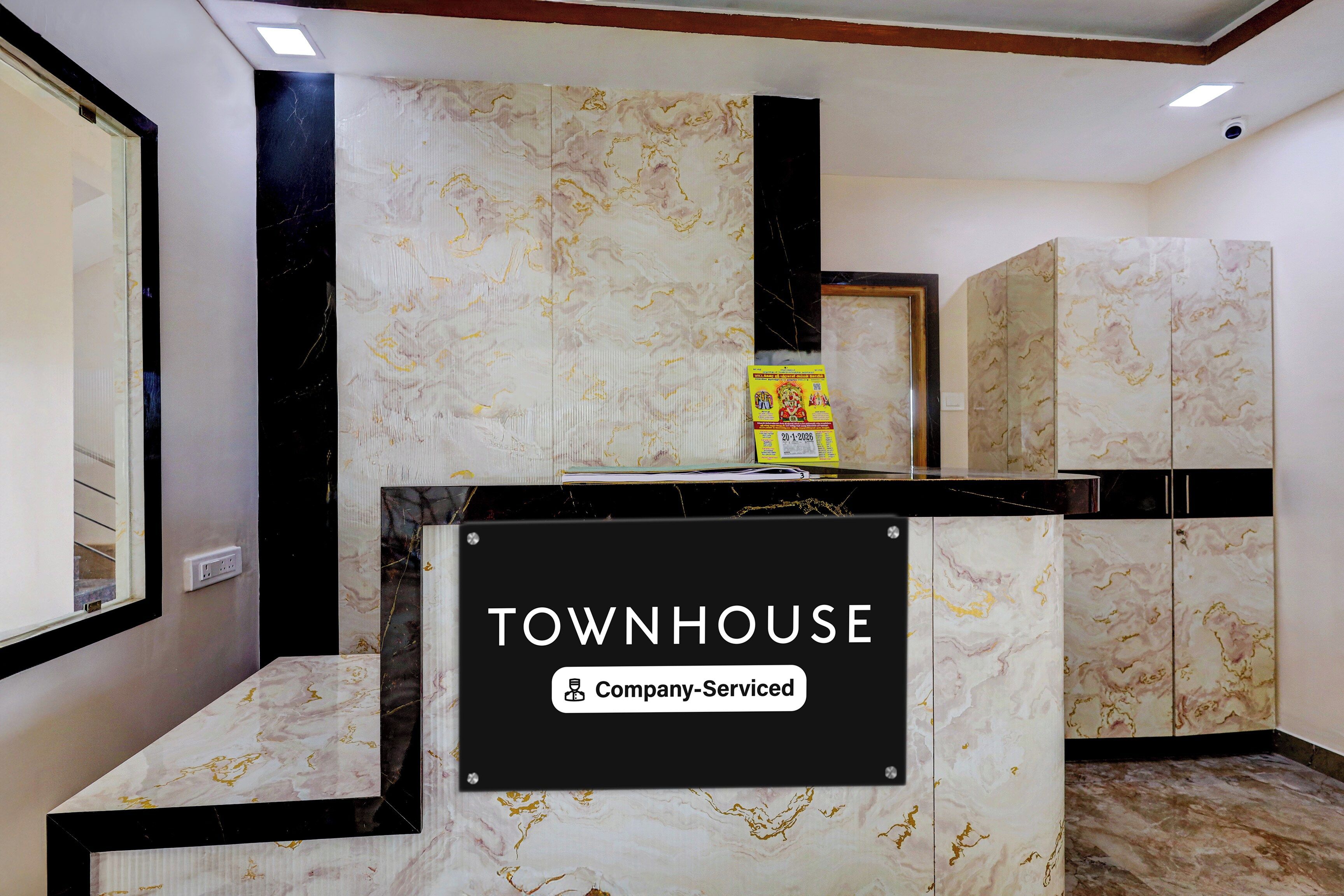 A reception desk with a sign reading 'TOWNHOUSE Company Serviced'.