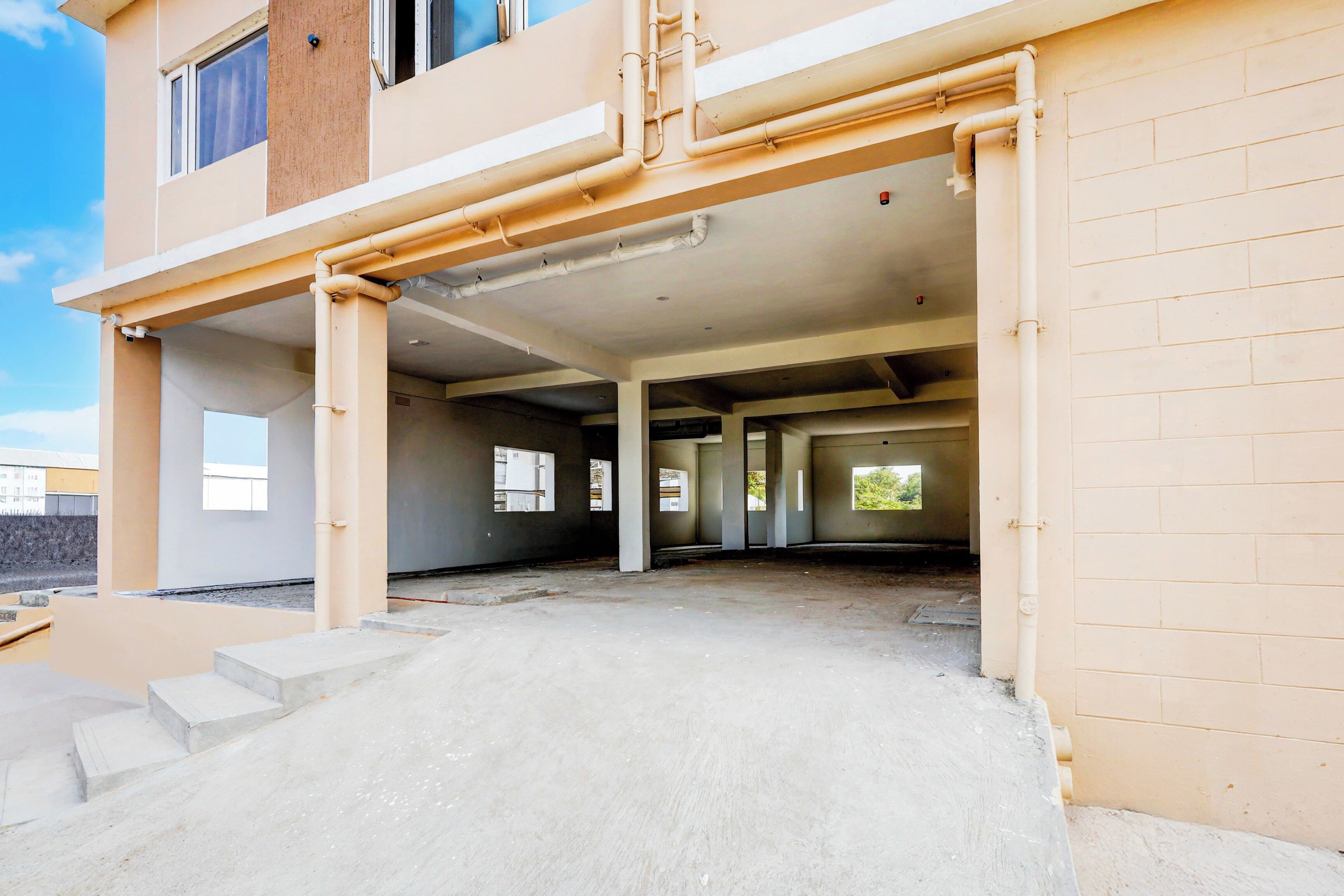 Un edificio de varios niveles en construcción, con pisos de concreto a la vista y espacios interiores sin terminar.