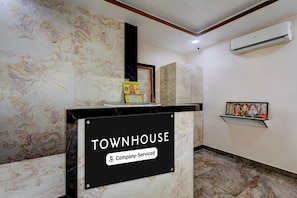 A reception desk with a sign reading 'TOWNHOUSE & Company-Serviced.'