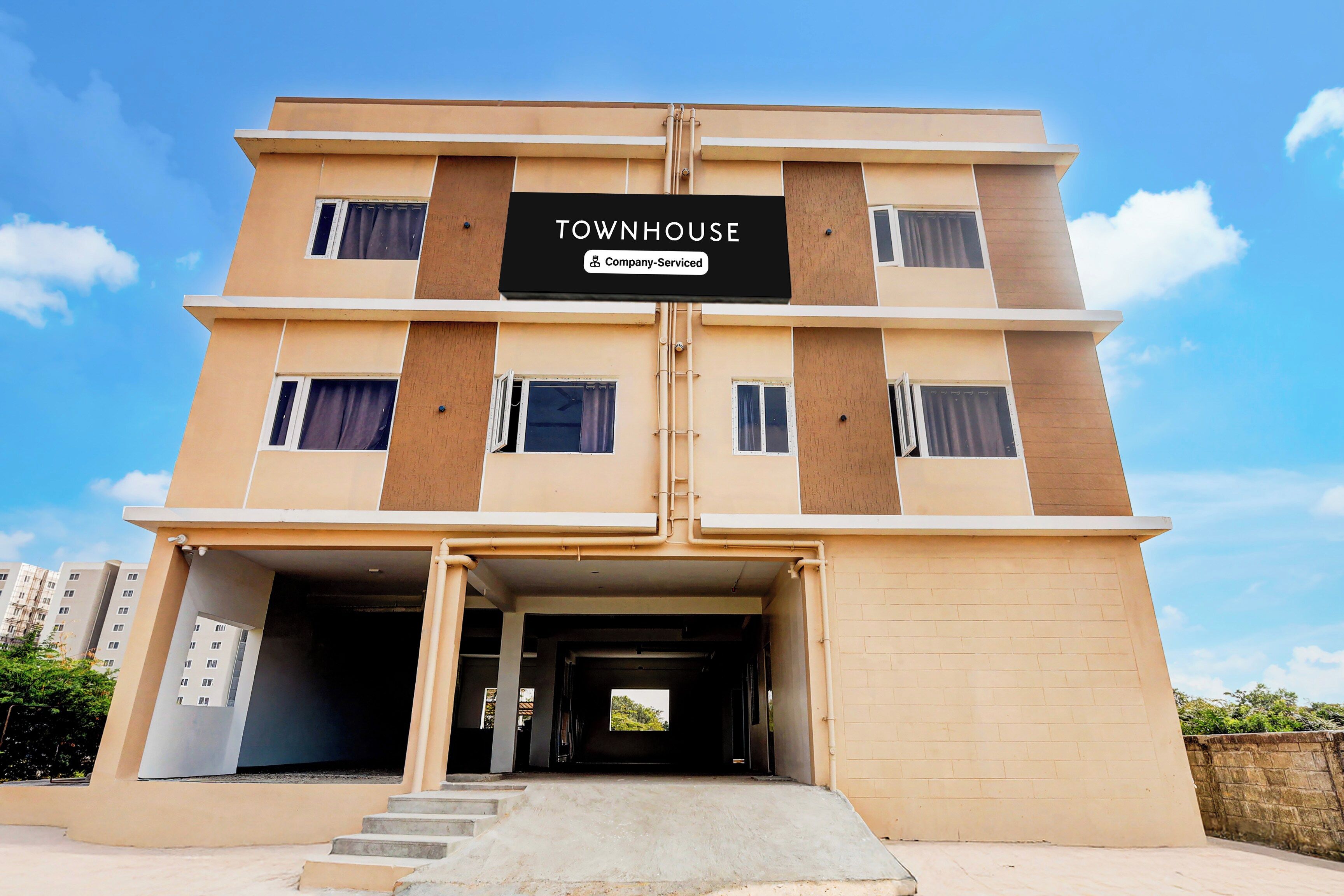 Un edificio de varios pisos con un letrero que dice 'TOWNHOUSE Company-Serviced'.