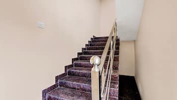 Una escalera con barandilla y un interruptor de luz en la pared.