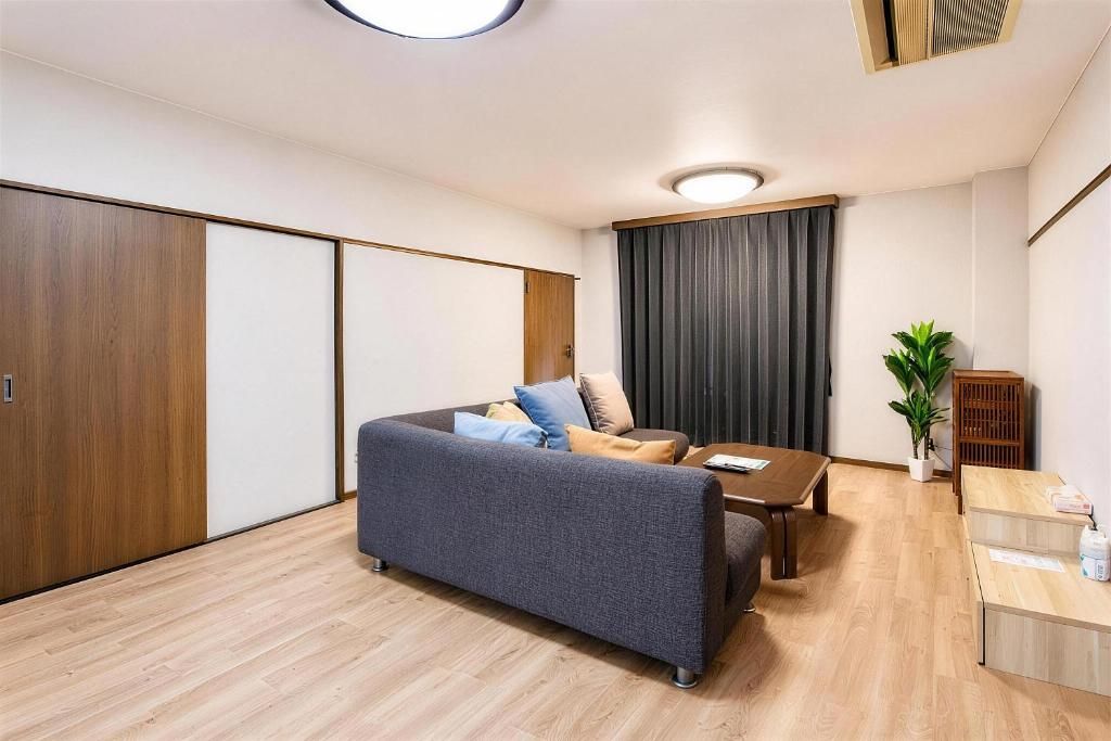 A modern living room with a sofa, a coffee table, and a small dining area.