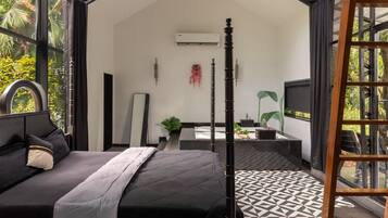 A modern bedroom with a bed, a bedside table, a TV, and a balcony with a view of greenery.