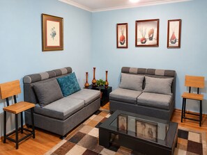 A living room with two grey sofas, a coffee table, and three framed artworks on the wall. - 3-bedroom apartment in welcoming Quito (Quito)