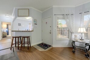 A clean, well-lit entryway with a wooden floor, a bench, a door with a 'No Smoking' sign, and a window with a view of the outside. - Great Location! Kissimmee Condo 5 Mi to Disney (Kissimmee)