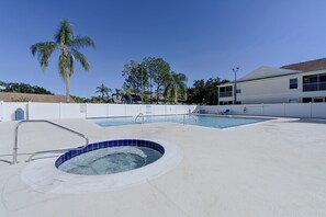 A swimming pool area with a hot tub, palm trees, and a building in the background. - Great Location! Kissimmee Condo 5 Mi to Disney (Kissimmee)