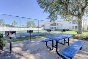 A fenced outdoor area with picnic tables and trash bins. - Great Location! Kissimmee Condo 5 Mi to Disney (Kissimmee)