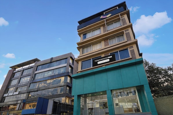 A multi-story building with a sign indicating it is company-serviced. - Townhouse Oak Siliguri (Siliguri)