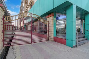 A gated entrance with a staircase leading to a building with a glass facade. - Townhouse Oak Siliguri (Siliguri)