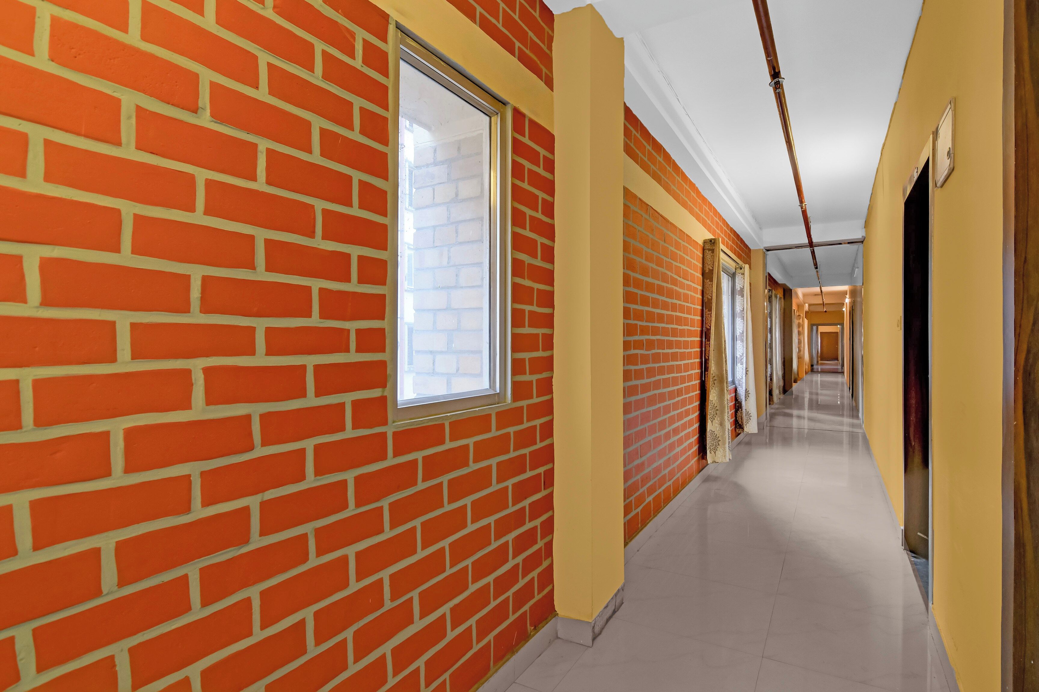 A corridor with brick walls and large windows.