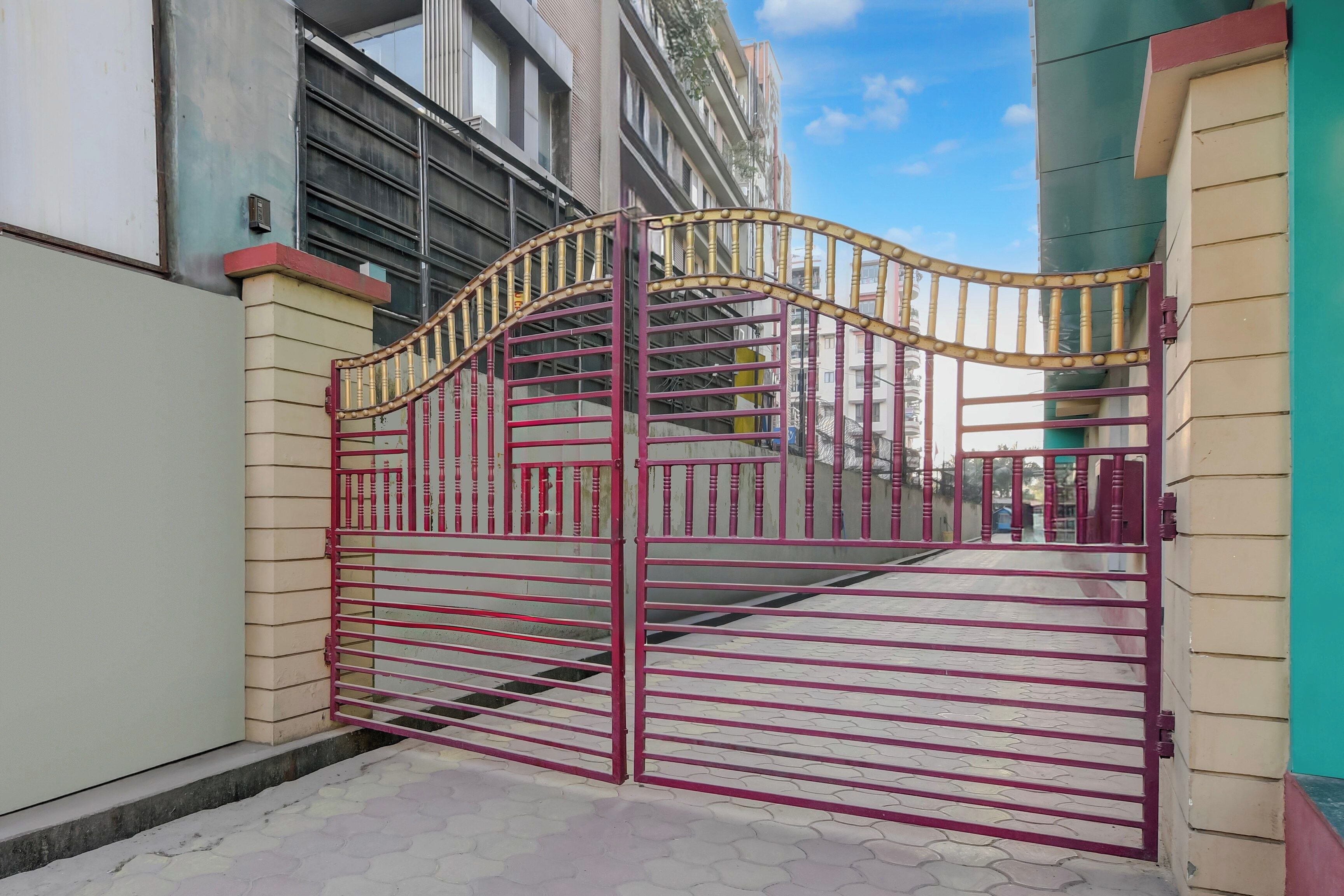 A gated entrance with a metal gate and a staircase leading to a building.