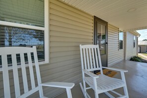 A porch with two white chairs and a door. - Fishing Pond! Quiet, Renovated Family Farmhouse! (Brownsville)