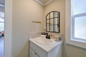 A bathroom with a white sink, black faucet, and a mirror with a black frame. - Lake Norman Views! Tiny Home w/ Deck (Sherrills Ford)