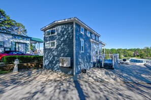 A two-story building with a covered porch and a garage. - Lake Norman Views! Tiny Home w/ Deck (Sherrills Ford)