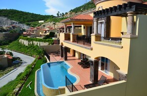 A resort with a swimming pool, multiple balconies, and a hillside backdrop. - PBMC · Pueblo Bonito Montecristo Owners Estate 3BR3B (Cabo San Lucas)