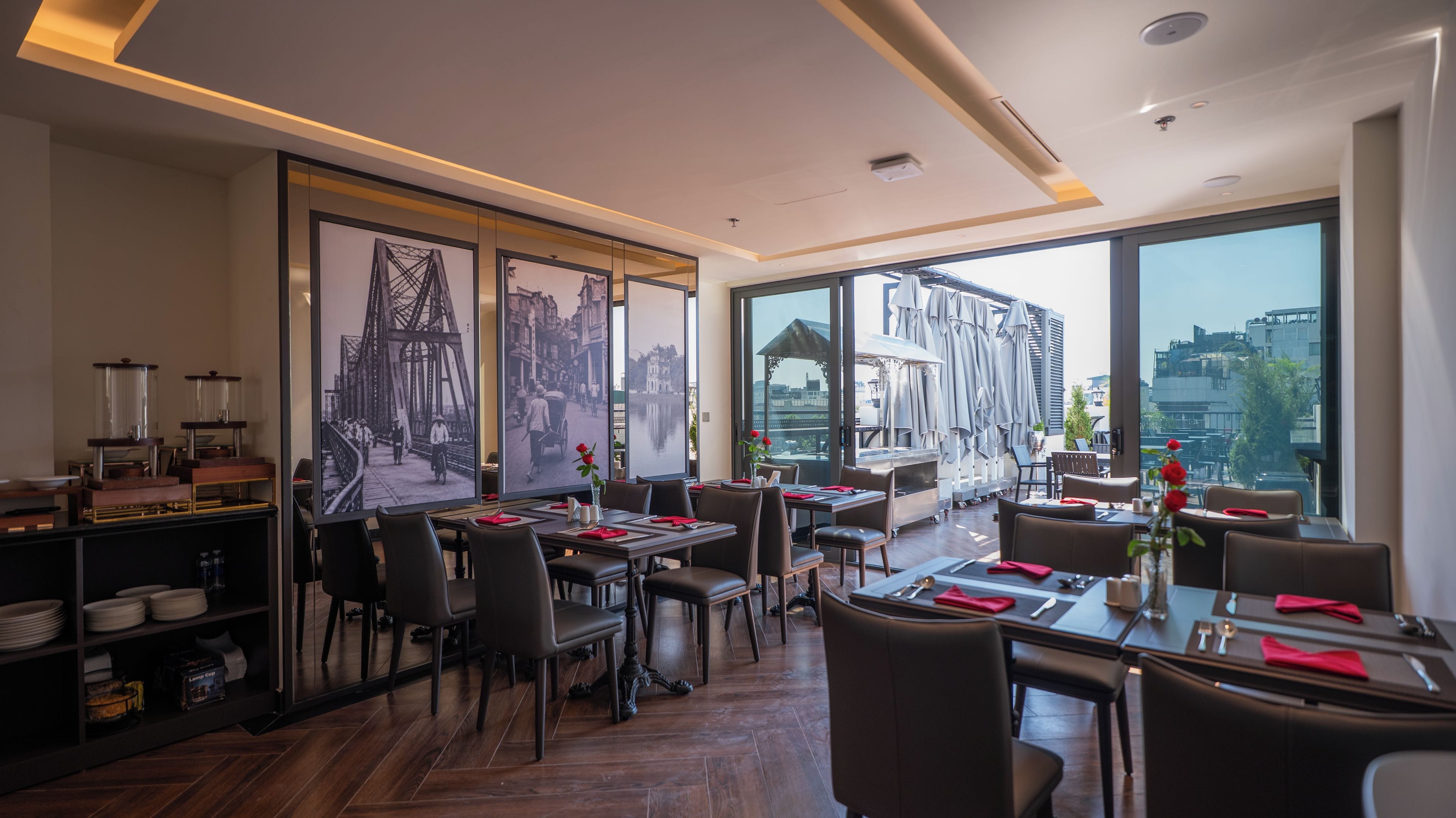 A restaurant with a modern interior, large windows, and a view of the city.