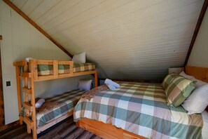 A dormitory room with two bunk beds, a single bed, and a checkered bedspread. - Hocking Hills Area Retreat: Relax & Explore! (Rockbridge)