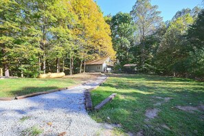 A gravel path leading to a house surrounded by trees with yellow leaves. - Hocking Hills Area Retreat: Relax & Explore! (Rockbridge)