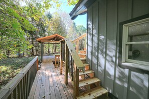 A wooden deck with a wooden staircase leading to a covered area. - Hocking Hills Area Retreat: Relax & Explore! (Rockbridge)