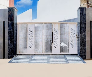 A gated entrance with a decorative metal gate featuring leaf patterns. - Classic Maharaja Grand (New Delhi)