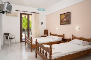 A hotel room with two wooden beds, a television, a chair, and a painting on the wall. - Archontiko Studios (Zakynthos)