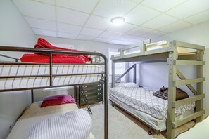 Une chambre avec un lit superposé, une fenêtre, un bureau et une chaise.