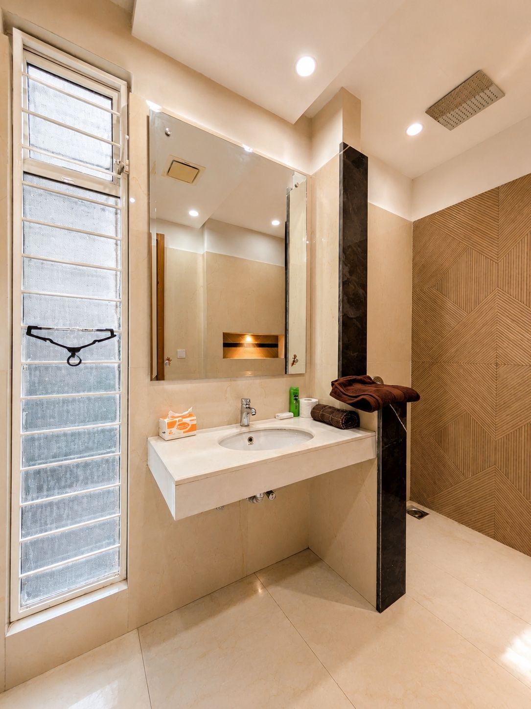 A modern bathroom with a large mirror, a sink, and a towel rack.