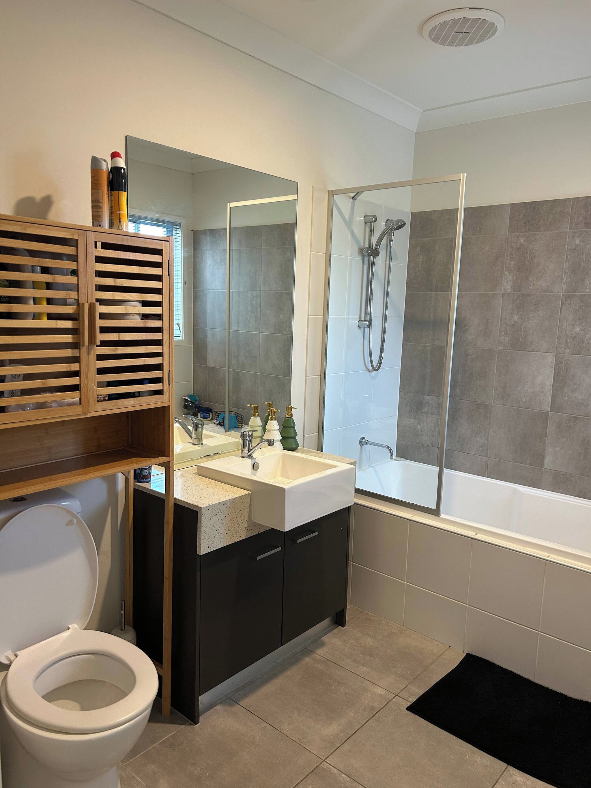 A modern bathroom with a toilet, sink, and shower.