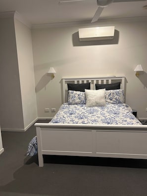 A bedroom with a white bed, a ceiling fan, and two wall-mounted lamps. - Spacious 3-Bedroom House Rental in Waterford, Australia (Waterford)