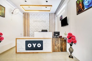 Ein Empfangstresen mit einem Schild mit der Aufschrift 'OYO' und einem modernen Innendesign.