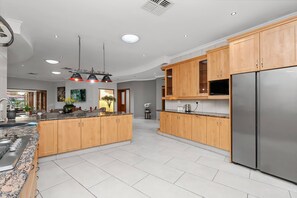 A modern kitchen with wooden cabinets, stainless steel appliances, and a granite countertop. - Luxurious 4-Bedroom Villa with Private Pool in Hartbeespoort (Hartbeespoort)