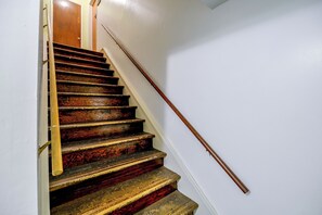 A wooden staircase with a handrail, leading to an upper floor. - Historic Welch Retreat! Ride, Hike & Explore (Welch)