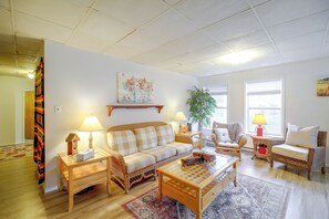 A living room with a sofa, two chairs, a coffee table, a lamp, a plant, and a painting on the wall. - Historic Welch Retreat! Ride, Hike & Explore (Welch)